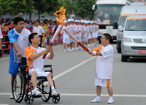 8月31日,火炬手陳建平(右)與下一棒火炬手曾軍進行交接。當(dāng)日,北京殘奧會圣火在長沙進行傳遞。 新華社記者 金良快 攝