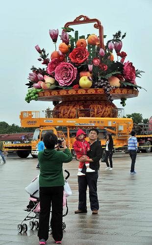 9月23日,游客在天安門廣場(chǎng)“花果籃”下拍照留念。 新華社記者 李文 攝