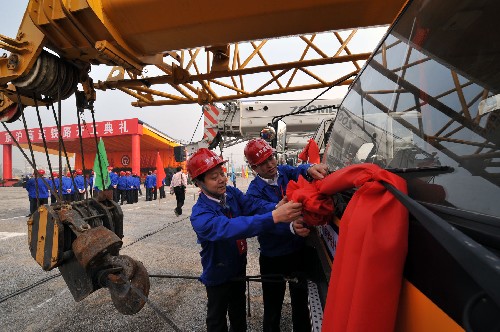 4月18日,參加京滬高速鐵路開工典禮的工人師傅在施工車上系大紅花。新華社記者 何俊昌 攝