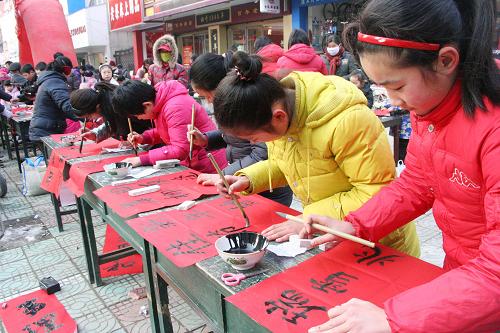 1月26日,安徽省含山縣青少年書法愛好者在街頭義務(wù)書寫春聯(lián)。當(dāng)日,安徽省含山縣60多位青少年書法愛好者走上街頭義務(wù)為群眾書寫春聯(lián),送上新春祝福。新華社發(fā)(程千俊 攝)