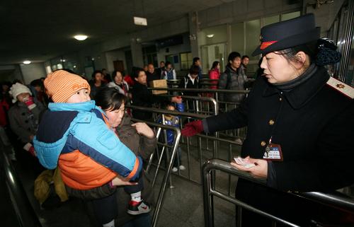 1月26日,廣西桂林市火車站工作人員在出站口加開的老弱婦女兒童專用通道維持秩序。新華社發(fā)(唐侃 攝)