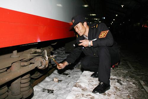 1月20日23時(shí),昆明至上海南K80次列車的檢車長(zhǎng)陳東波冒著冰雪嚴(yán)寒檢查車輛。新華社發(fā)(梅國(guó)建 攝)