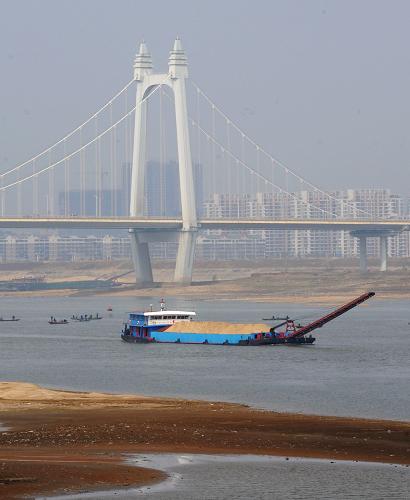 一艘貨船行駛在長沙市三汊磯大橋附近的湘江航道上(2月14日攝)。新華社記者 龍弘濤 攝