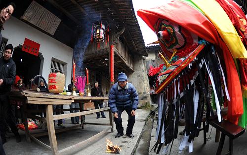 2月14日,浦江縣黃宅村的村民在板凳龍出發(fā)前將龍頭抬到祠堂內(nèi),進行出發(fā)前的祭祀儀式。新華社記者 徐昱 攝