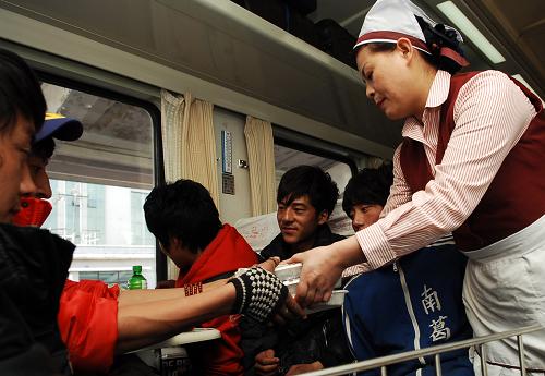 2月14日,乘務(wù)員在列車上給學(xué)生們分發(fā)午餐。新華社記者 王博 攝