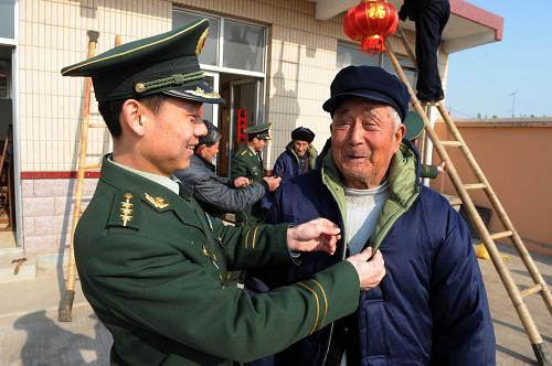 2月15日,肖江偉警官(左)幫著82歲的鄭明月老人試穿送來的新棉衣。新華社記者 李紫恒 攝