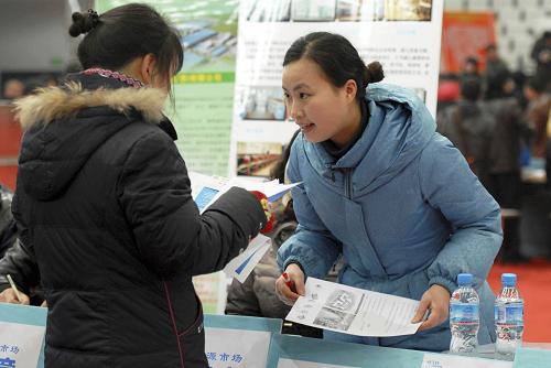 2月14日,在安徽淮南舉行的大型招聘會上,來自江蘇常熟市一家電子企業(yè)的工作人員汪德婭(右)向應聘者積極推薦崗位。新華社發(fā)(陳彬 攝)