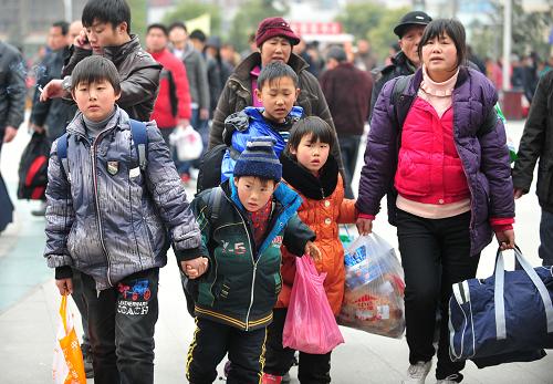 2月15日,幾位“小候鳥”在武昌火車站跟隨家人準備進站。新華社記者 郝同前 攝