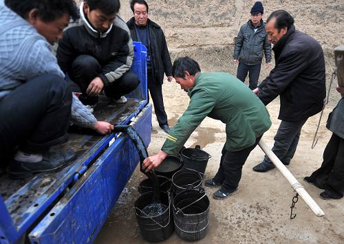 2月15日,通渭縣常河鄉(xiāng)陽坡村村民從拉水車上取水。新華社記者 聶建江 攝
