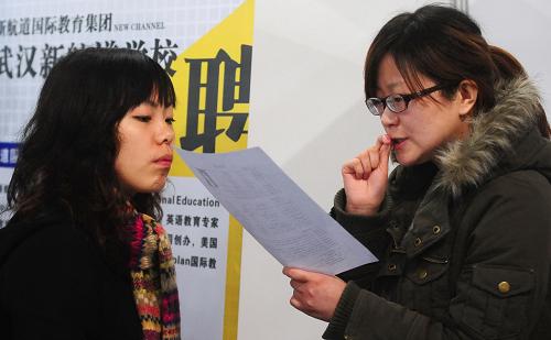 2月27日,一名求職學生(左)在一家培訓企業(yè)展區(qū)與招聘人員交流。新華社記者 程敏 攝