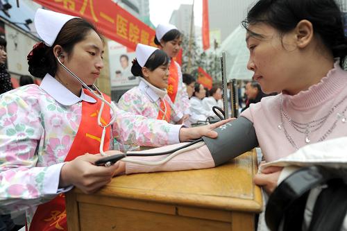 3月5日,南京第八一醫(yī)院服務(wù)志愿隊(duì)的醫(yī)務(wù)人員為市民測(cè)量血壓。當(dāng)日是中國(guó)青年志愿者服務(wù)日,即“學(xué)雷鋒日”,南京市白下區(qū)組織轄區(qū)多家單位在南京新街口正洪街廣場(chǎng)開(kāi)展學(xué)雷鋒宣傳服務(wù)活動(dòng)。新華社記者 韓瑜慶 攝