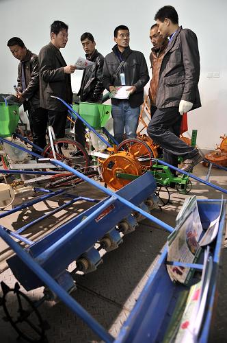 3月5日,幾位農(nóng)民在農(nóng)交會上選購農(nóng)機。新華社記者 王鵬 攝