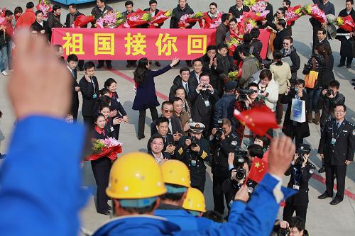 3月5日,從利比亞撤回的中國人員走下飛機旋梯,向迎接人員揮手致意。新華社發(fā)(金立旺 攝)