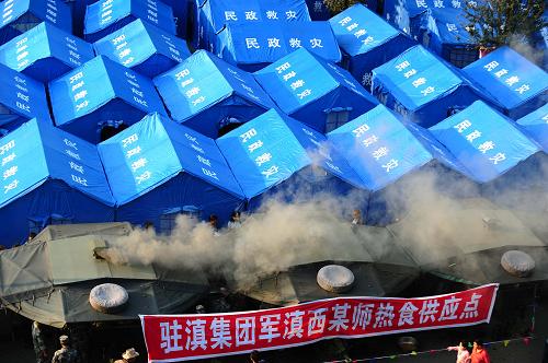 3月12日傍晚,野戰(zhàn)炊事車(chē)開(kāi)始在救災(zāi)安置點(diǎn)做飯。當(dāng)日,駐滇集團(tuán)軍某師的四輛野戰(zhàn)炊事車(chē)開(kāi)進(jìn)盈江地震災(zāi)區(qū)盈湖公園安置點(diǎn),現(xiàn)場(chǎng)為受災(zāi)群眾烹飪熱菜熱飯,并免費(fèi)發(fā)放。據(jù)悉,四輛炊事車(chē)可以解決千余人的飲食問(wèn)題。他們從今天開(kāi)始每天供應(yīng)兩頓熟食,將持續(xù)到救災(zāi)工作基本結(jié)束。新華社記者 秦晴 攝