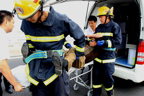 5月30日,救護(hù)人員將“車(chē)禍中的傷員”撤離事故現(xiàn)場(chǎng)。當(dāng)日,主題為“維護(hù)生命,保障暢通”的應(yīng)急搶險(xiǎn)實(shí)戰(zhàn)演練在上海長(zhǎng)江隧橋上舉行。演練模擬多車(chē)追尾相撞后,檢驗(yàn)各聯(lián)動(dòng)部門(mén)間協(xié)同搶險(xiǎn)作戰(zhàn)能力,旨在為2012年上海崇明島至江蘇啟東通道開(kāi)通運(yùn)營(yíng)后,積累大流量車(chē)流搶險(xiǎn)救援預(yù)案和搶險(xiǎn)實(shí)戰(zhàn)經(jīng)驗(yàn)。新華社記者 陳飛 攝