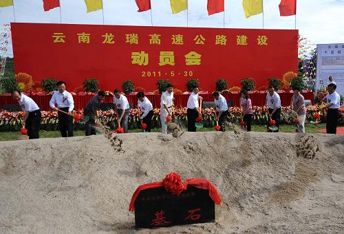 5月30日,出席活動(dòng)的嘉賓在中緬邊境的云南省德宏傣族景頗族自治州瑞麗市為龍瑞高速公路項(xiàng)目奠基。當(dāng)日,云南龍瑞高速公路建設(shè)指揮部在中緬邊境的云南省德宏傣族景頗族自治州瑞麗市舉行建設(shè)動(dòng)員大會(huì)并為高速公路項(xiàng)目奠基。龍瑞高速公路起于云南省保山市龍陵縣龍山卡,與保(山)龍(陵)高速公路相連,途經(jīng)德宏州芒市,止于瑞麗市姐勒,是國家高速公路網(wǎng)杭州至瑞麗公路的重要組成部分,也是云南重點(diǎn)推進(jìn)的出境國際大通道之一。公路主線全長128.4公里,建設(shè)標(biāo)準(zhǔn)為雙向四車道,建設(shè)工期預(yù)計(jì)為4年,概算總投資約107億元。目前,云南省正加快出境國際大通道的建設(shè),中越、中老泰、中緬等國際大通道境內(nèi)段全部實(shí)現(xiàn)高等級(jí)化。截至2010年,云南省高速公路通車?yán)锍踢_(dá)2630公里,出省通邊、內(nèi)外連通的高速公路主干道骨架初步形成。新華社記者 藺以光 攝
