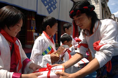 6月1日,在中華民族園,參加活動(dòng)的孩子們獲贈(zèng)書(shū)籍。當(dāng)日,北京民族文化遺產(chǎn)保護(hù)基金會(huì)開(kāi)展“六一”玉樹(shù)孤兒游園及捐贈(zèng)活動(dòng),邀請(qǐng)?jiān)诤5硗鈬?guó)語(yǔ)實(shí)驗(yàn)學(xué)校就讀的18名玉樹(shù)地震藏族孤兒來(lái)到中華民族園,與藏族工作人員一起歌舞聯(lián)歡,在“家鄉(xiāng)”的氛圍中度過(guò)自己在北京的第一個(gè)兒童節(jié)。新華社記者 趙琬微 攝