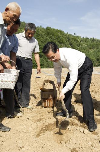 這是胡錦濤在視察受旱農(nóng)田時(shí),拿著鋤頭和村民一起補(bǔ)種玉米。新華社記者 黃敬文 攝