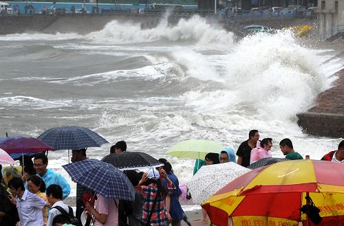 6月26日,游客在青島第六海水浴場觀看強(qiáng)熱帶風(fēng)暴帶來的大浪。新華社記者 李紫恒 攝