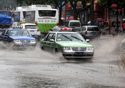6月26日,汽車經(jīng)過青島四流南路一段低洼積水路段,強(qiáng)熱帶風(fēng)暴給青島帶來局部大到暴雨。新華社記者 李紫恒 攝