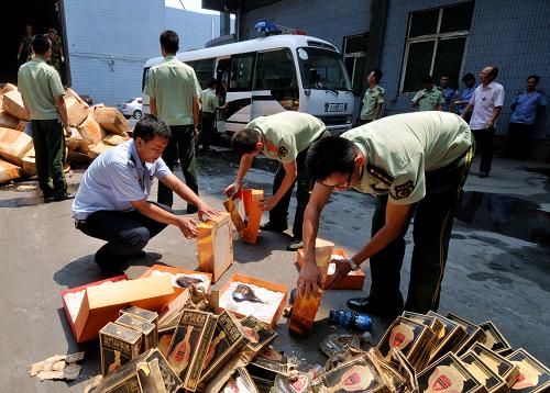 8月22日,福建省泉州市工商管理局工作人員與泉州邊防支隊官兵一同處理涉案假冒、偽劣洋(白)酒。當(dāng)日,福建省泉州市工商管理局聯(lián)合泉州邊防支隊在福建省石獅市錦尚鎮(zhèn)一垃圾處理廠集中銷毀1000多箱共計10000多瓶的涉案假冒偽劣洋(白)酒。這些假酒中,有假冒“金門高粱”“五糧液”“軒尼詩XO”“藍帶馬爹利”“人頭馬XO”等名貴酒。據(jù)介紹,這些假酒大都采用外用真包裝、內(nèi)里裝假酒等方式進行混裝,仿真度較高,一般市民無法識別,且假酒都用甲醇或工業(yè)酒精勾兌,對人體危害極大。新華社記者 魏培全 攝
