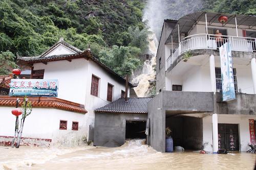 8月22日,在湖北省興山縣,山洪傾瀉而下,從一間房屋穿堂而過(guò)。新華社發(fā)(鄒遠(yuǎn)景 攝)