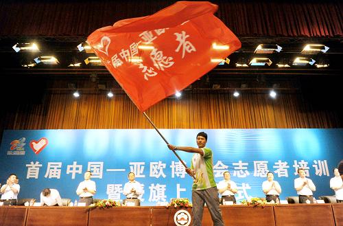 8月23日,一名志愿者代表在上崗儀式上揮舞志愿者旗幟。當(dāng)日,首屆“中國(guó)—亞歐博覽會(huì)”志愿者授旗上崗儀式暨崗前培訓(xùn)在新疆大學(xué)禮堂召開。身穿統(tǒng)一服裝的1000名展會(huì)志愿者在上崗儀式上宣誓并接受相關(guān)培訓(xùn)。此次博覽會(huì)共組織招募了11000余名城市志愿者和展會(huì)志愿者進(jìn)行服務(wù)。新華社記者 王菲 攝