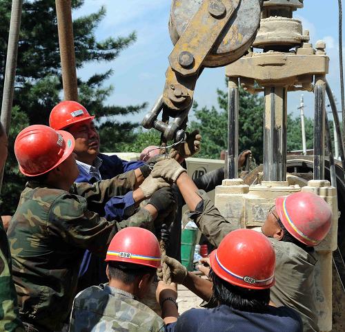 8月24日,救援人員在地面打井施救。新華社記者 王松 攝