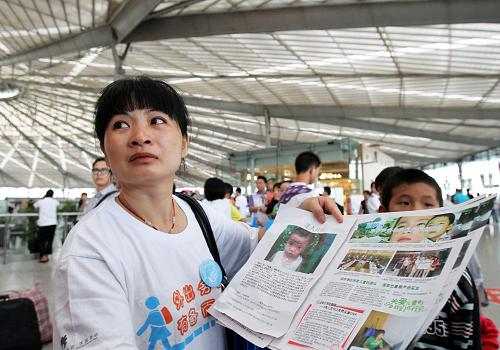 8月25日,防拐志愿者萬光碧(左)在上海南站候車大廳內(nèi)參與防拐宣傳。她的兒子于4年前在江西老家被拐,至今未找到。新華社記者 劉穎 攝