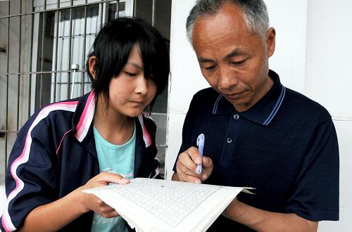 “大別山師魂”汪金權(quán)老師課后輔導(dǎo)學(xué)生作文(2010年5月27日攝)。新華社記者 皮曙初 攝