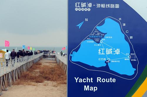 隨著水位的急劇下降,近十多年來,紅堿淖風(fēng)景區(qū)的游客碼頭,已向前延伸300余米(10月12日攝)。畫面右側(cè)的示例圖也只是曾經(jīng)的湖面圖。新華社記者 陶明 攝