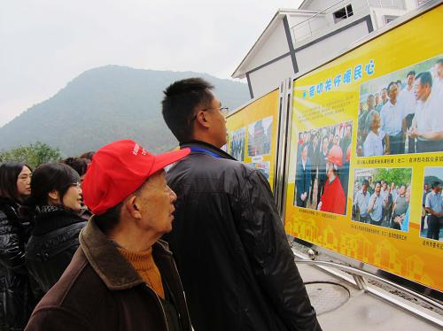 11月18日,在四川省達(dá)州市宣漢縣君塘鎮(zhèn)洋烈村,人們?cè)谟^看全國(guó)新農(nóng)村文化藝術(shù)展演圖片展。新華社發(fā)(鄧良奎 攝)