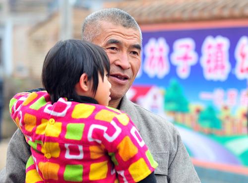 11月21日,甘肅省正寧縣榆林子鎮(zhèn)石家村村民尤善元抱著5歲的外孫女李一諾,從10公里外趕到新組建的幼兒園。新華社記者 梁強(qiáng) 攝