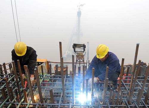 1月1日,施工工人在160多米高的跨海大橋主塔塔頂進(jìn)行電焊,該主塔完工后高度將達(dá)到170多米。新華社記者 徐昱 攝