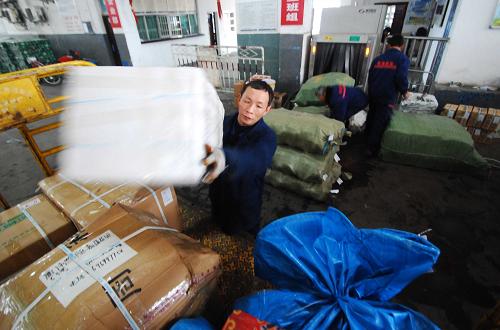 1月3日,在江西九江火車站行李房,中鐵快運公司的工作人員將發(fā)送的包裹裝車。據(jù)中鐵快運九江站營業(yè)部介紹,受鄱陽湖旱情導致魚蝦鮮貨運量減少、部分客運列車行李車解掛造成運能不足以及民營快遞公司業(yè)務(wù)擴張等因素影響,2011年江西九江中鐵快運年業(yè)務(wù)量比2010年下降15%左右,江西其他地區(qū)中鐵快運年業(yè)務(wù)量下降約5%。新華社發(fā)(胡國林 攝)