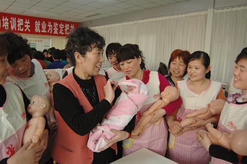2月21日,在濟(jì)南陽(yáng)光大姐家政服務(wù)培訓(xùn)中心,來(lái)自山東各地的學(xué)員在老師(左三)的指導(dǎo)下學(xué)習(xí)包裹新生兒。新華社發(fā)(張振祥攝)