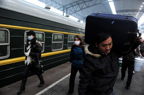 L160次列車到達(dá)終點(diǎn)站安徽阜陽,乘客們攜帶著行李出站(1月21日攝)。新華社記者 郭晨 攝