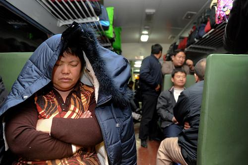L160次列車上,一位乘客將衣服遮蓋在頭頂上入睡(1月20日攝)。新華社記者 郭晨 攝