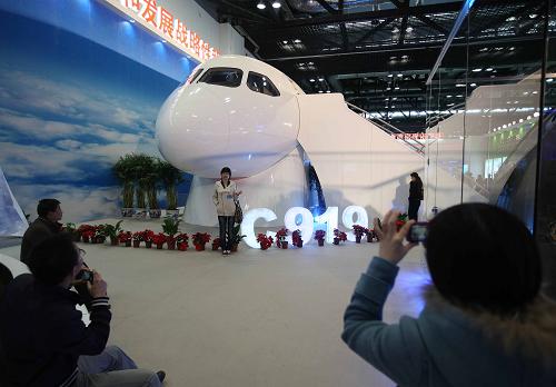 3月8日,參觀者在C919大型客機(jī)旁留影。當(dāng)日,主題為“自主創(chuàng)新,重點(diǎn)跨越”的“十一五”國(guó)家重大科技成就展在北京開幕,國(guó)產(chǎn)大飛機(jī)——C919大型客機(jī)在展覽上亮相。新華社發(fā)(李方宇 攝)