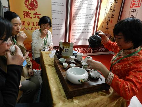 4月20日,在北京展覽館舉行的“茶博會”上,工作人員請觀眾品茶。新華社發(fā)(王振 攝)