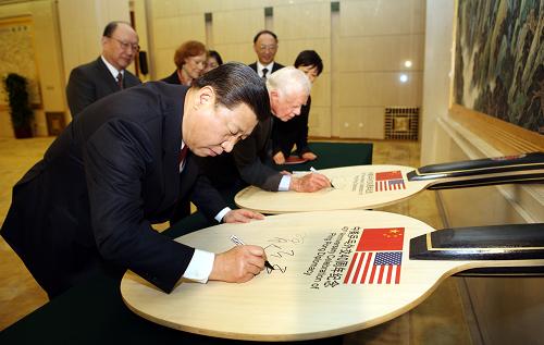 12月8日,中國人民對外友好協(xié)會和國家體育總局在北京人民大會堂舉行中美“乒乓外交”四十周年紀(jì)念活動。國家副主席習(xí)近平、美國前總統(tǒng)卡特共同出席并致辭。這是習(xí)近平和卡特共同在中美“乒乓外交”四十周年紀(jì)念球拍上簽名留念。 新華社記者 姚大偉 攝