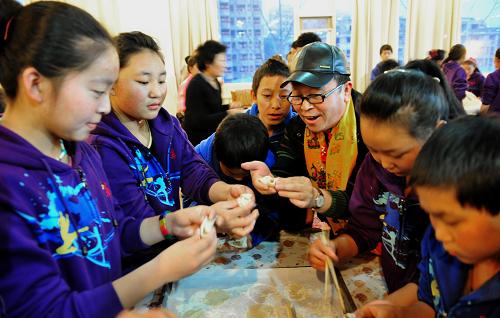 12月24日,晚會(huì)結(jié)束后,志愿者和玉樹藏族孩子一起包餃子。新華社記者 劉海峰 攝