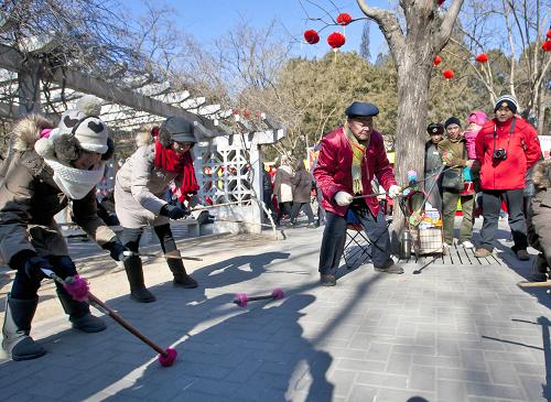 1月24日,游客在北京廠甸廟會上向民間藝人學習耍花棍。 春節(jié)期間,在各地舉行的廟會等文化活動中,非物質(zhì)文化遺產(chǎn)項目展示紛繁多樣,使人們在游玩的同時更深入地感受民族、民俗文化氛圍。 新華社發(fā)(趙冰 攝)