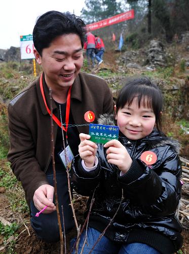 “我在張家界有棵樹”——張家界啟動百萬游客萬畝優(yōu)質(zhì)果林助農(nóng)計劃 3月12日,一名小游客將標(biāo)識卡掛在栽種的果樹上。標(biāo)識卡用于建立果樹網(wǎng)絡(luò)檔案,游客可以通過網(wǎng)絡(luò)了解自己栽種的果樹成長情況。 當(dāng)日,來自海內(nèi)外的數(shù)百名游客,在湖南張家界大峽谷景區(qū)周邊開展栽種優(yōu)質(zhì)果樹助農(nóng)活動。 據(jù)介紹,張家界大峽谷景區(qū)計劃投資1000萬元實施“栽樹助農(nóng)”計劃,計劃用5年時間,組織近百萬游客,將張家界大峽谷景區(qū)周圍的貧山旱地改造成收入豐厚的萬畝優(yōu)質(zhì)果林。到收益期,至少可為當(dāng)?shù)剞r(nóng)民增加5000萬元以上收入。 新華社記者白禹攝