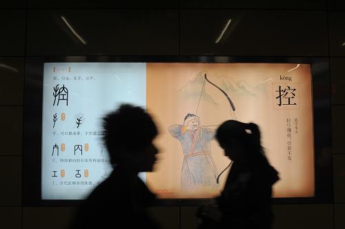 4月19日,乘客從北京地鐵4號(hào)線平安里站的一處漢字文化宣傳燈箱前走過。北京市計(jì)劃在地鐵6號(hào)線、8號(hào)線北段、9號(hào)線、10號(hào)線二期、7號(hào)線、14號(hào)線等線路的58個(gè)新建重點(diǎn)站中設(shè)立公共藝術(shù)品,以提升地鐵公共文化藝術(shù)水平。這些地鐵站的藝術(shù)化設(shè)計(jì),將緊密結(jié)合地面的人文景觀情況,選取相同或相似的元素向地下延伸。新華社發(fā)(劉長龍 攝)