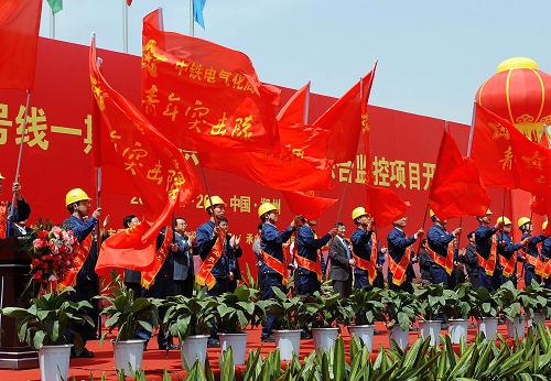 4月26日,中鐵電氣化局青年突擊隊(duì)的隊(duì)員們?cè)陂_(kāi)工儀式現(xiàn)場(chǎng)揮舞隊(duì)旗。新華社記者 李安 攝