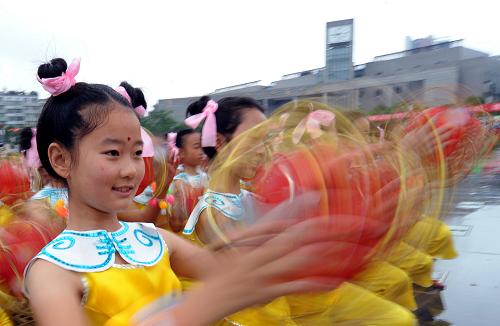 5月22日,四川省廣安市廣安區(qū)的學(xué)生在思源廣場(chǎng)表演傳統(tǒng)民俗節(jié)目“宕渠云童舞”。新華社發(fā)(邱海鷹 攝)