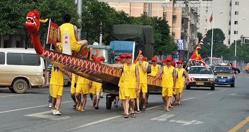 6月19日,長(zhǎng)沙社區(qū)居民推著龍舟前往瀏陽(yáng)河邊參加下水儀式。新華社記者 龍弘濤 攝