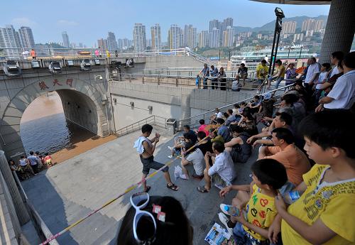 7月6日,猛漲的江水已經(jīng)淹至重慶朝天門碼頭的門洞,不少市民紛紛在朝天門碼頭的門洞前觀水。 當(dāng)日14時(shí),長(zhǎng)江干流寸灘水文站(重慶)水位漲至181.43米,超過警戒水位0.93米,長(zhǎng)江上游干流出現(xiàn)今年以來首次超警戒水位洪水。 新華社記者 劉潺 攝