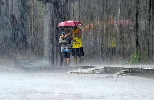 7月13日,在湖北省武漢市江岸區(qū),行人被困在雨中。新華社發(fā)